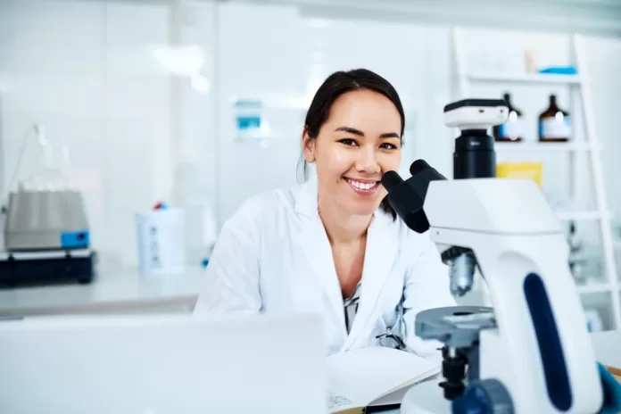 Pesquisadora em laboratório utilizando microscópio para estudos em saúde aquática