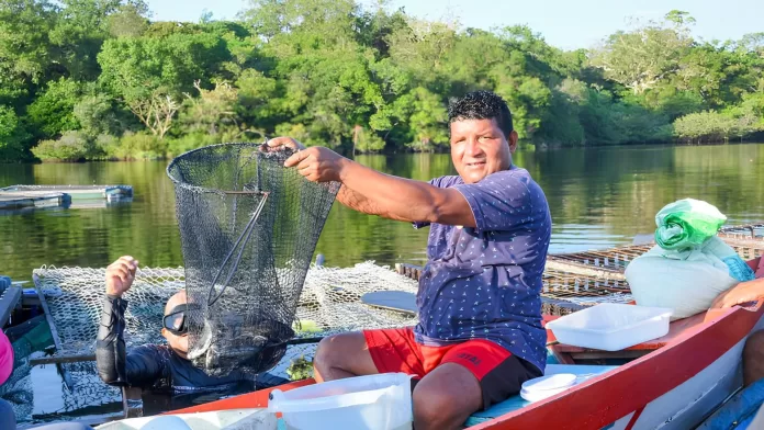 Produtor mostra rede de peixes em projeto de aquicultura familiar em Santarém