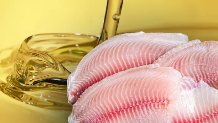 Filés de tilápia-do-Nilo crus com óleo sendo derramado ao fundo