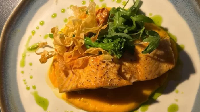 Prato com robalo grelhado servido com legumes e purê