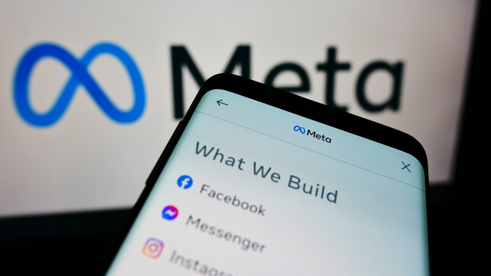 Smartphone exibindo os ícones das redes sociais Facebook, Messenger e Instagram com o logótipo da Meta em destaque ao fundo.
